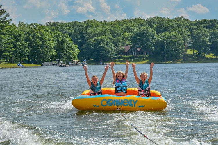 three kids on a large inflatable on the lake